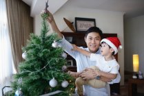 Asiatische Familie feiert Weihnachten, Vater und Sohn schmücken Tanne — Stockfoto