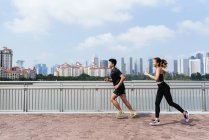 Счастливая азиатская спортивная пара бегает вместе — стоковое фото