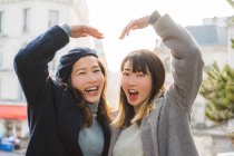 Young adult asian female friends with hands forming heart shape — Stock Photo