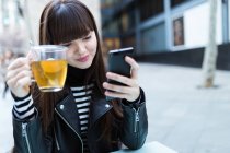 Long hair women looking at her smartphone — Stock Photo