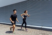 Asiatico coppia running contro muro — Foto stock