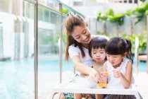 Kids enjoying snack together with mother. — Stock Photo