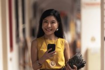 Heureux jeune asiatique femme en utilisant smartphone — Photo de stock