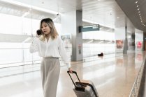 Молода успішна бізнес-леді зі смартфоном в аеропорту — стокове фото