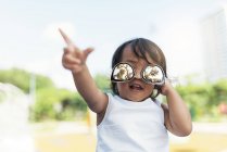 Милая маленькая азиатская девочка в солнечных очках на размытом фоне — стоковое фото