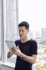 Bell'uomo d'affari asiatico che lavora con tablet in ufficio — Foto stock