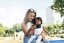 Young mother with asian daughter taking selfie — Stock Photo