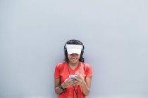 Joven asiático deportivo mujer usando auriculares y elegante - foto de stock
