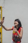Азиатка со смартфоном и напитками — стоковое фото