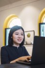 Молода азіатська жінка використовує ноутбук у творчому сучасному офісі — стокове фото