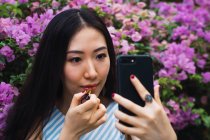 Jovem asiático mulher tomando selfie e aplicando batom — Fotografia de Stock
