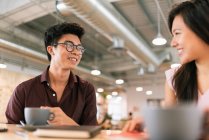 Giovani imprenditori asiatici parlando in ufficio moderno — Foto stock