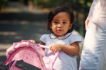 Cute asian mother and daughter with baby carriage in park — Stock Photo
