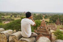 Joven tomando fotos en la pagoda Shwesandaw (Bagan, Myanmar ) - foto de stock
