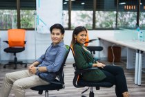 Young asian business people in modern office — Stock Photo