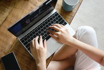 Imagen recortada de la mujer usando el ordenador portátil en casa - foto de stock