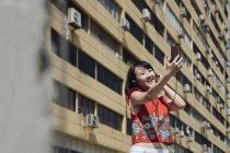 Asiática turista mujer tomando selfie contra casa - foto de stock
