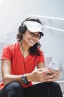 Giovane asiatica donna sportiva utilizzando cuffie e smart — Foto stock