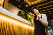 Giovane donna asiatica con intelligente e bere in confortevole bar — Foto stock