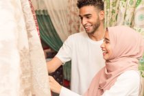 Joven pareja musulmana comprando telas en una tienda - foto de stock