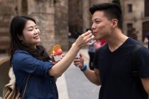 Portrait of young tourist couple eating ice cream on the street. — Stock Photo