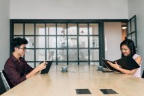 Молодые азиатские предприниматели, работающие в современном офисе — стоковое фото