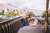 Giovane hipster donna che si rilassa dal balcone a casa a Queenstown, Nuova Zelanda — Foto stock