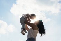 Jeune mère tenant asiatique fille dans les mains — Photo de stock