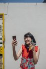 Asiatische Touristin mit einem Kamerafon und Getränk — Stockfoto
