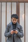 Молодой привлекательный случайный азиатский мужчина с помощью смартфона — стоковое фото