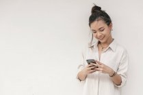 Junge asiatische Frau mit Lächeln mit Smartphone — Stockfoto