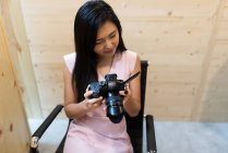 Junge asiatische erfolgreiche Geschäftsfrau mit Kamera im modernen Büro — Stockfoto