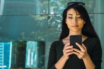 Portrait of young asian woman using smartphone — Stock Photo