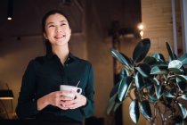 Mujer de negocios adulta joven con taza de café - foto de stock