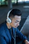 Retrato de joven asiático hombre con auriculares blancos - foto de stock