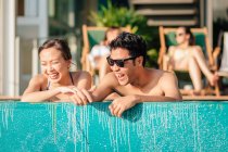 LIBÉRATIONS Attrayant jeune couple asiatique relaxant dans la piscine — Photo de stock