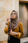 Jeune asiatique musulman femme dans hijab fabrication bulles — Photo de stock