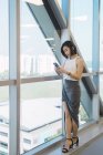 Jeune asiatique femme d'affaires en utilisant smartphone dans le bureau moderne — Photo de stock