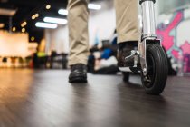 Imagem cortada do homem com scooter no escritório moderno — Fotografia de Stock
