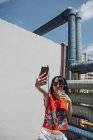 Asiatin mit Kopfhörer macht Selfie — Stockfoto