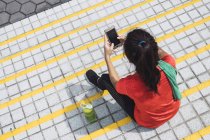 Jovem asiático mulher desportiva usando smartphone — Fotografia de Stock