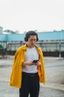 Крутий молодий азіатський чоловік використовує смартфон на відкритому повітрі — стокове фото