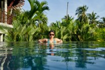 Jeune femme asiatique relaxante dans une piscine — Photo de stock