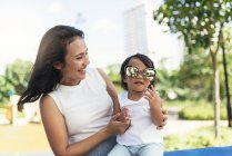 Молода мати з азіатською дочкою в сонцезахисних окулярах — стокове фото