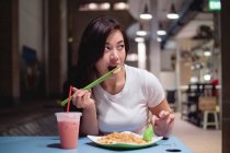 Азійка їсть місцеву їжу. — стокове фото