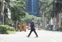 Jovem empresário bem sucedido cruzando rua — Fotografia de Stock