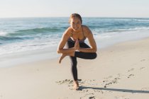 Jeune belle femme pratiquant le yoga en plein air — Photo de stock