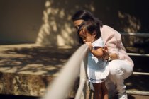 Милые азиатские мать и дочь глядя из перила в парке — стоковое фото