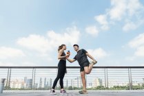Happy asian sporty couple together, man making stretching — Stock Photo