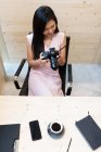 Молодая успешная азиатка с камерой в современном офисе — стоковое фото